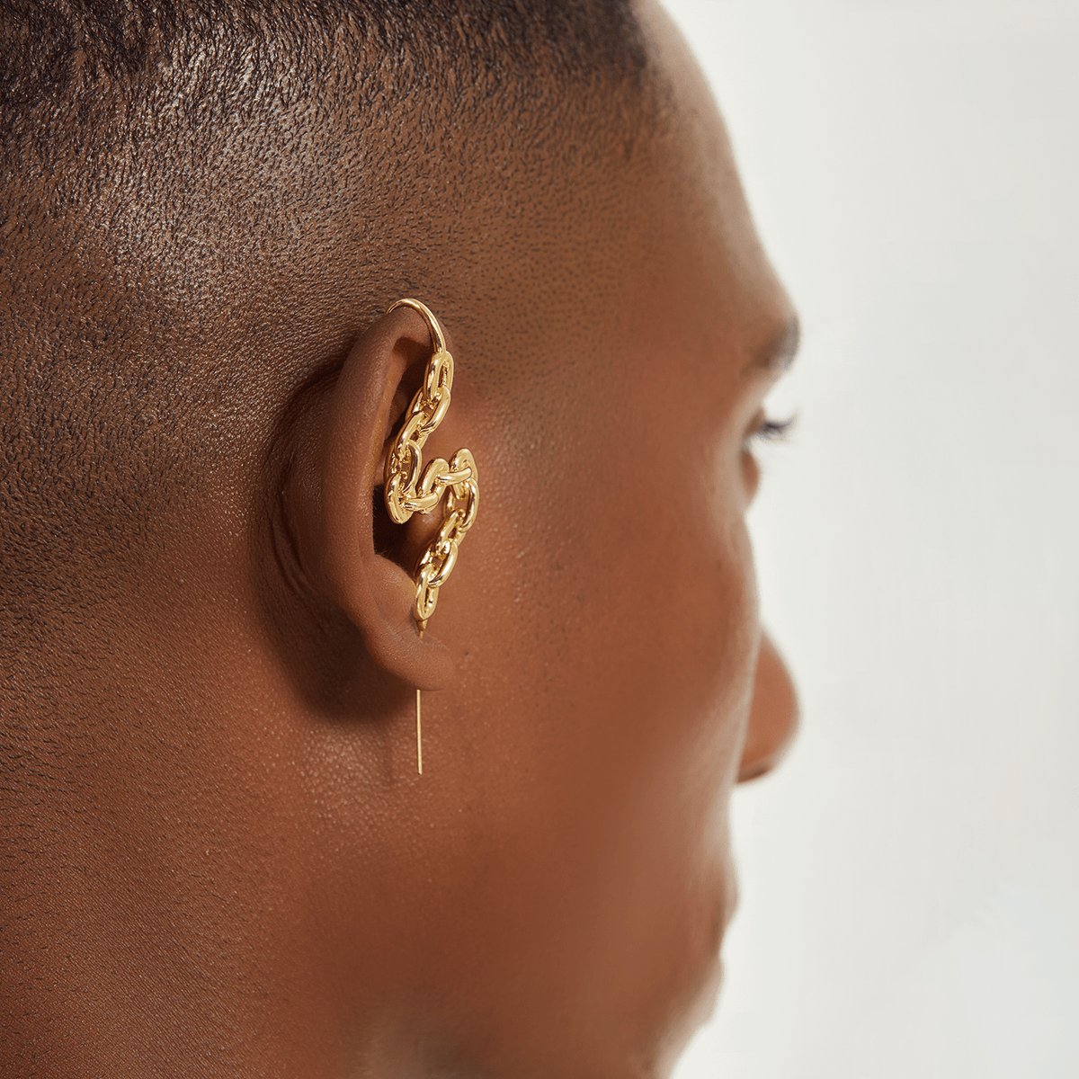 Chain-Link ear cuff in gold worn on the ear, profile view