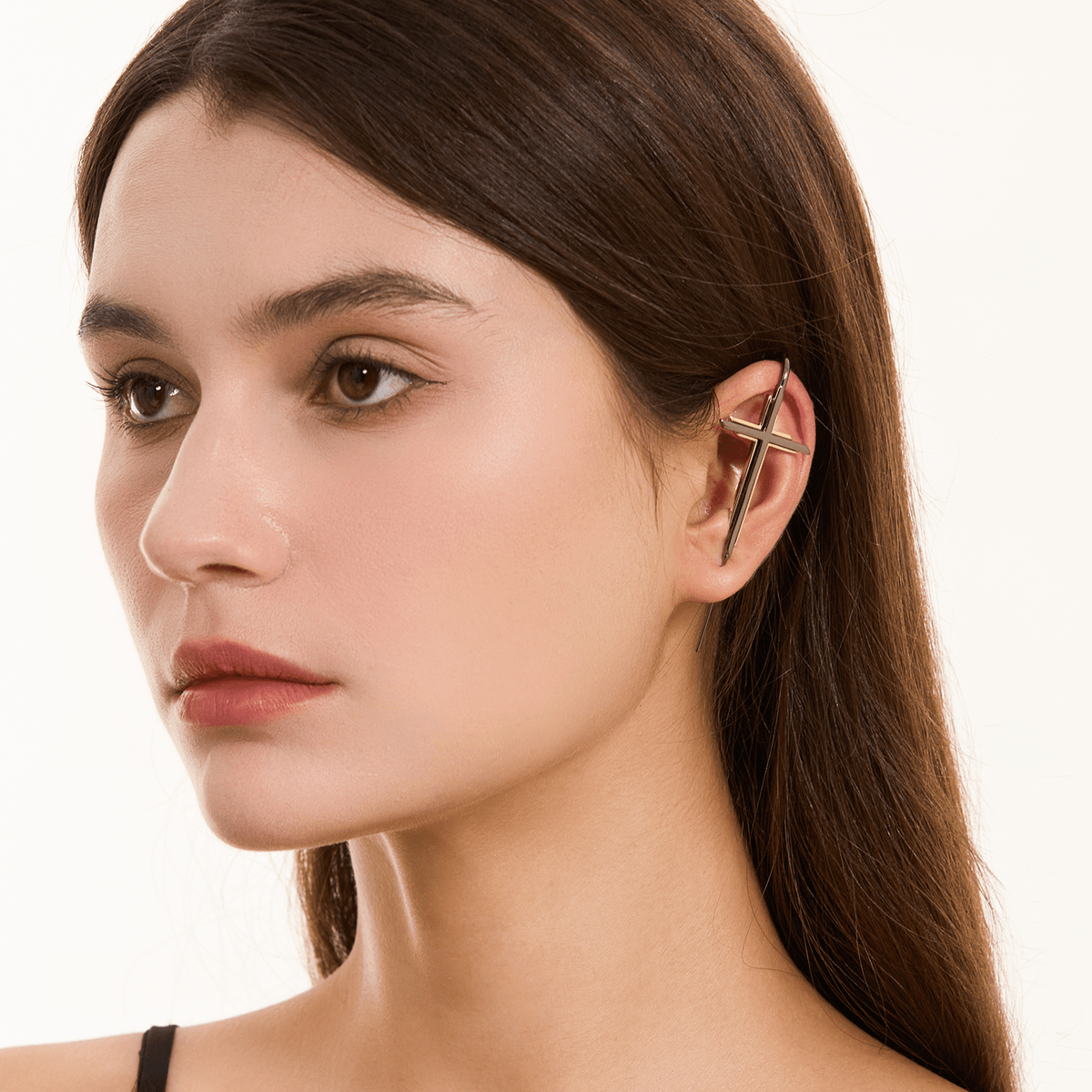 Cross ear cuff in black worn on the ear, profile view