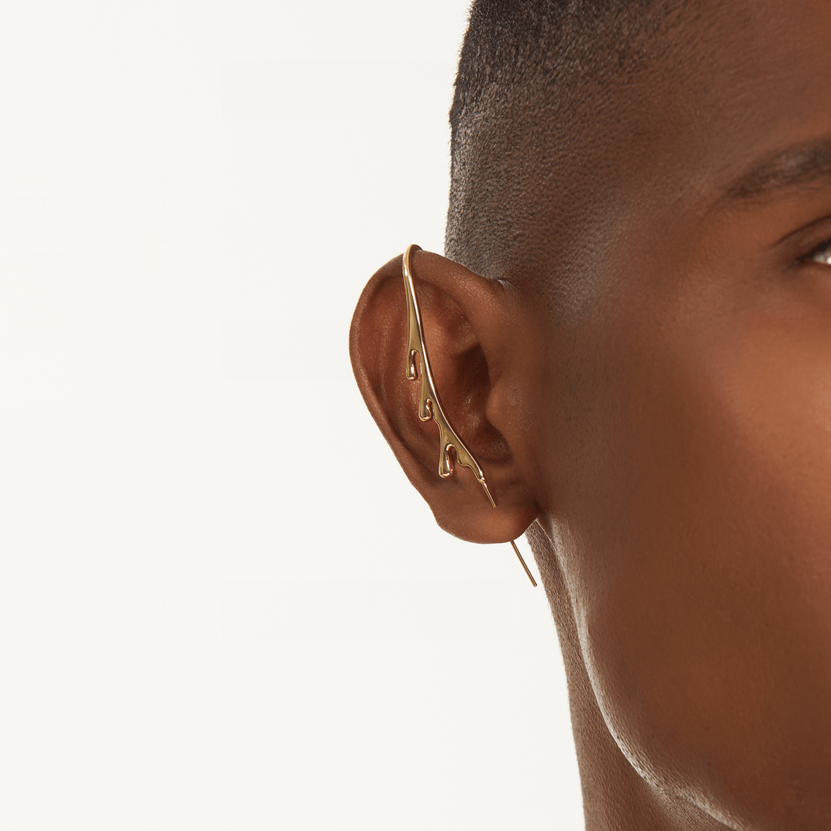 Drip ear cuff in gold worn on the ear, profile view