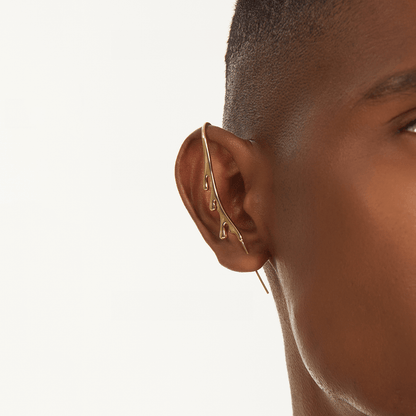 Drip ear cuff in gold worn on the ear, profile view