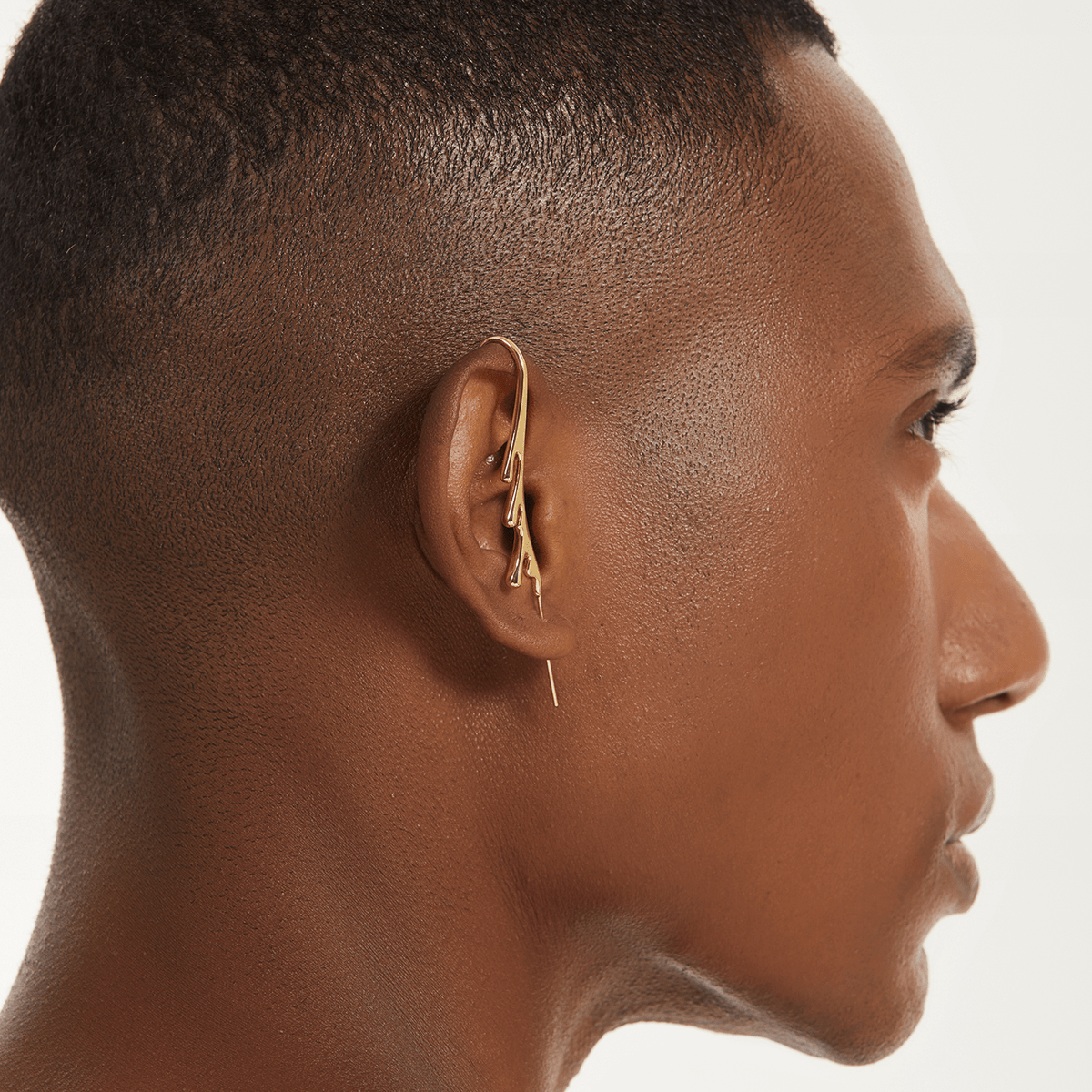 Drip ear cuff in gold worn on the ear, profile view