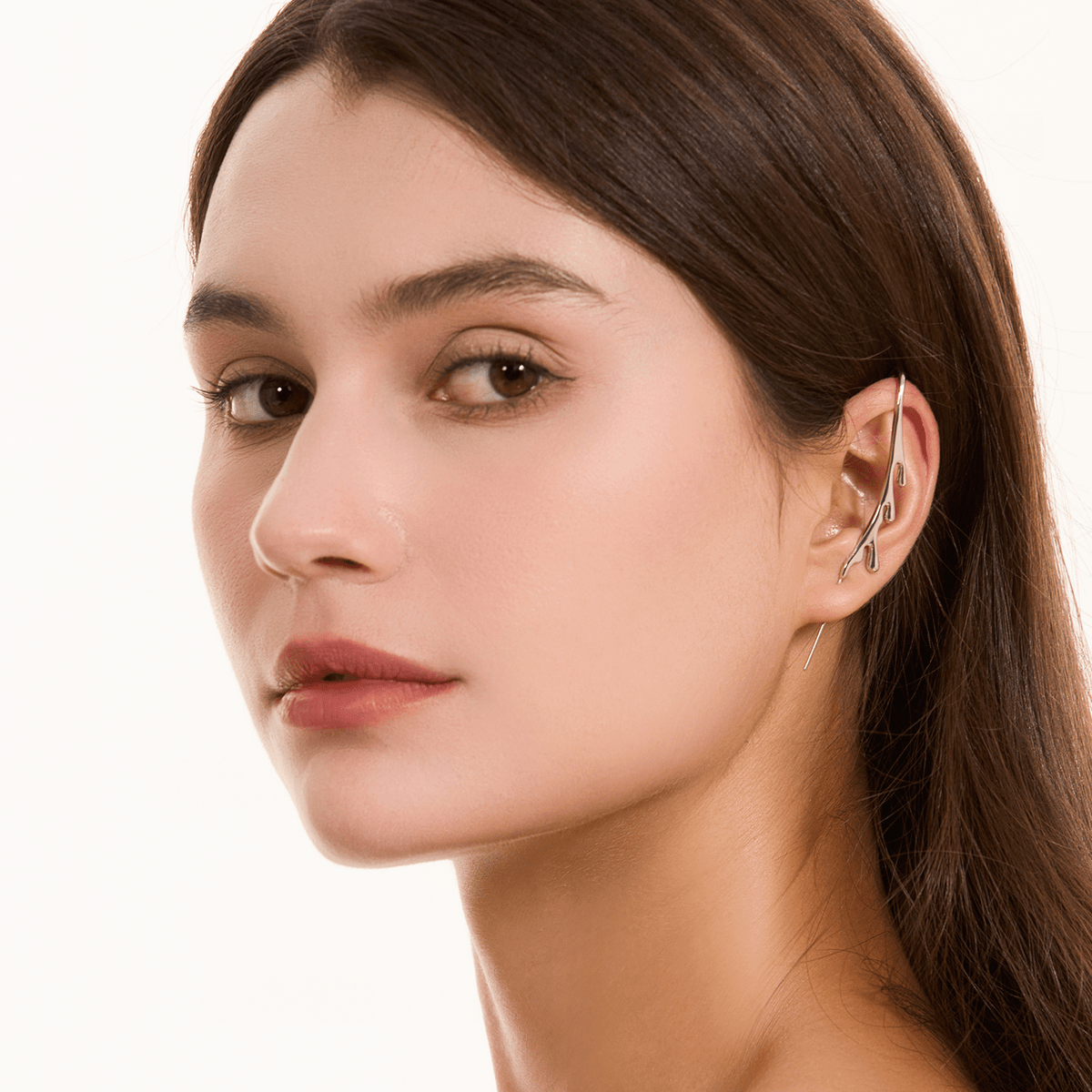 Drip ear cuff in silver worn on the ear, profile view