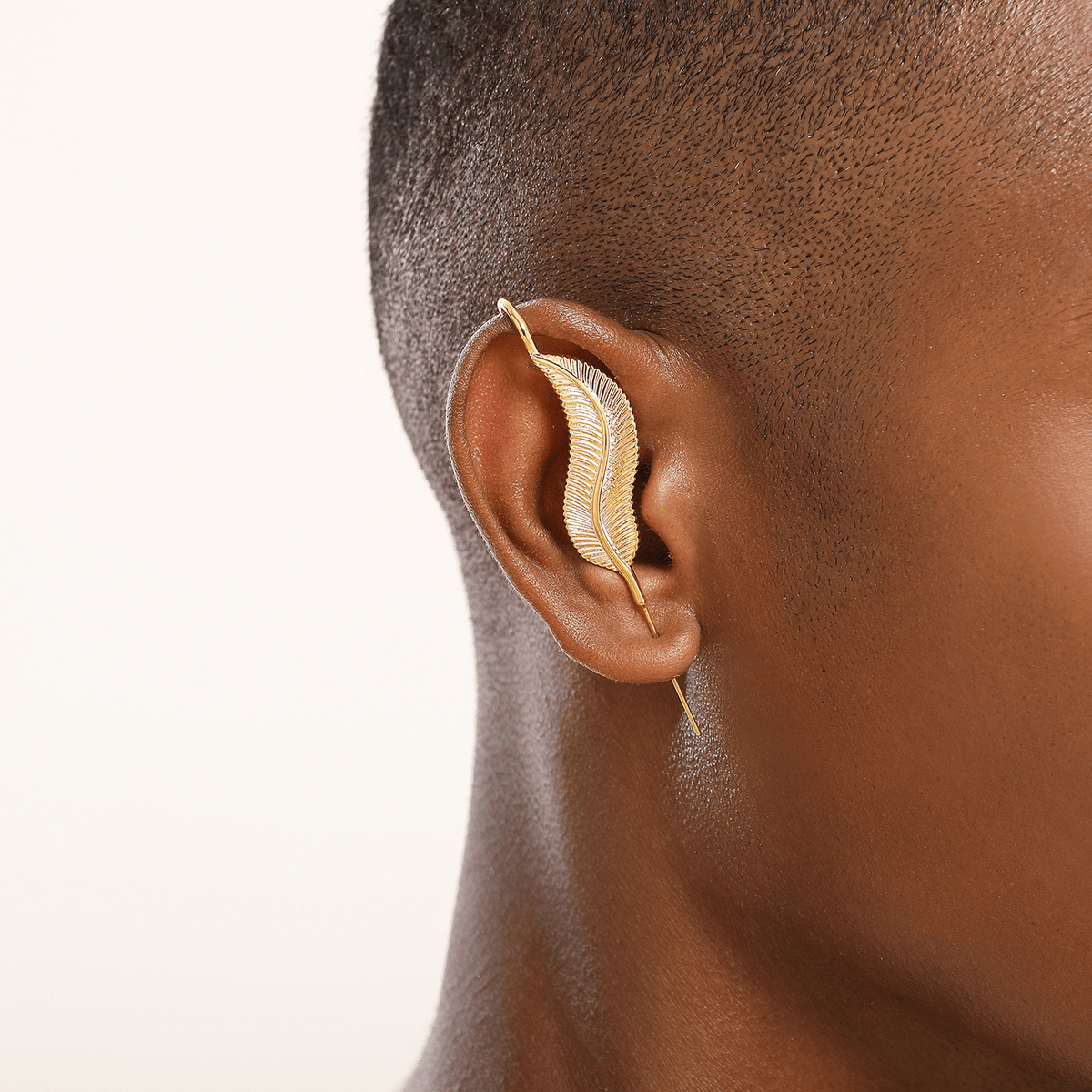 Feathered Grace ear cuff in gold worn on the ear, profile view