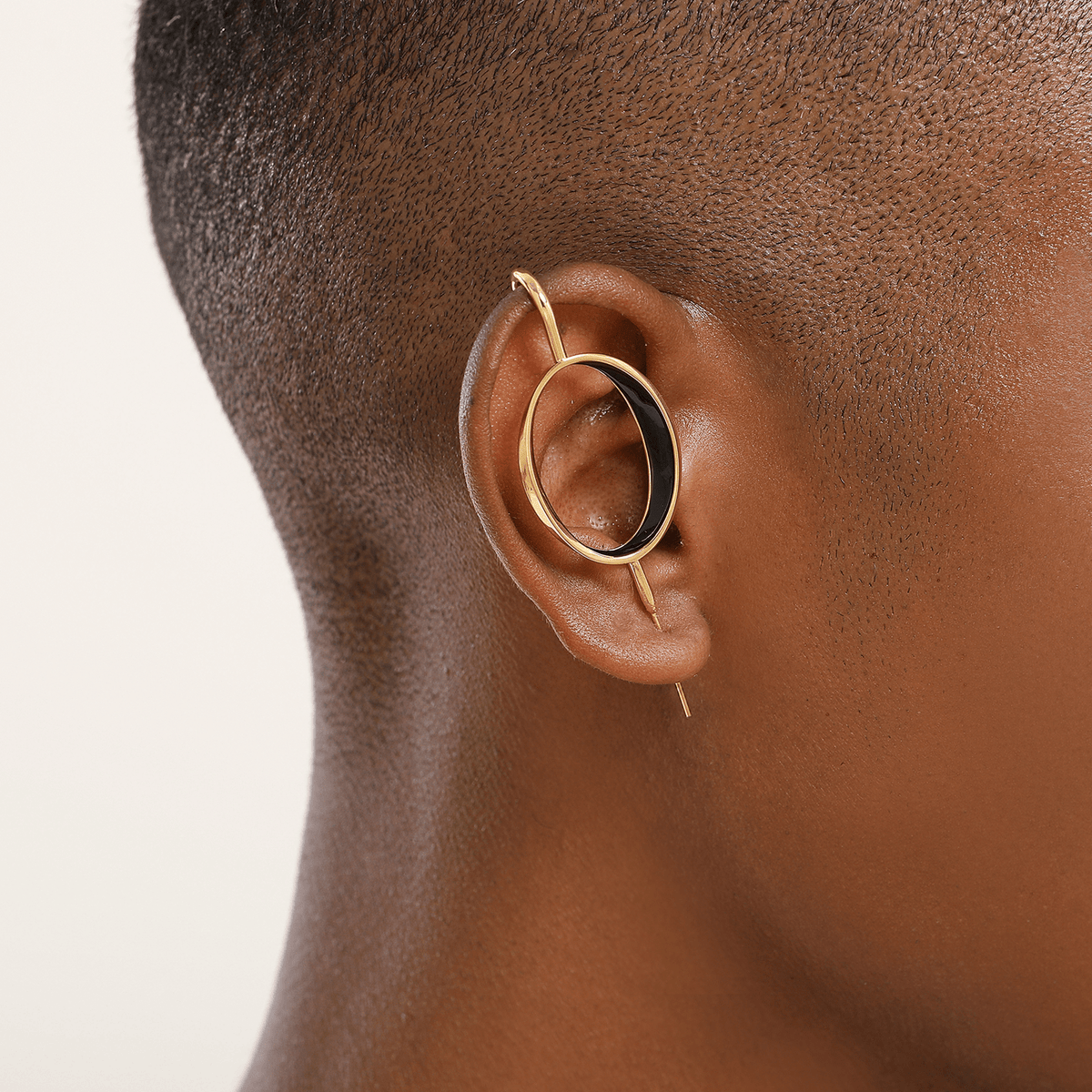 Halo ear cuff in gold worn on the ear, profile view