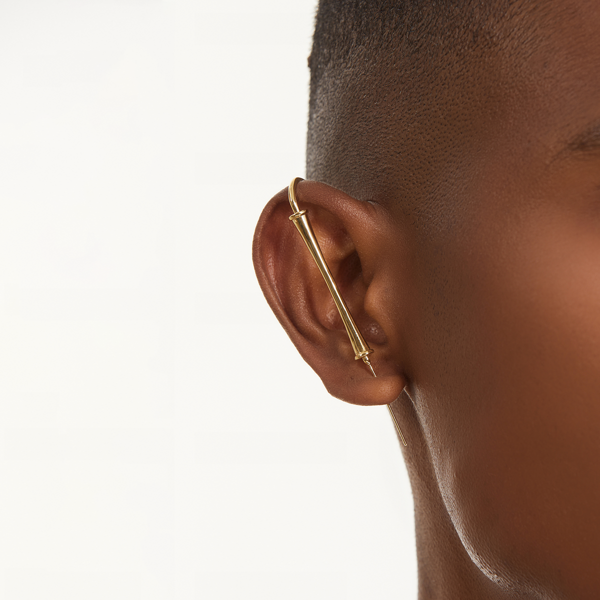 Pillar of Fortitude ear cuff in gold worn on the ear, profile view