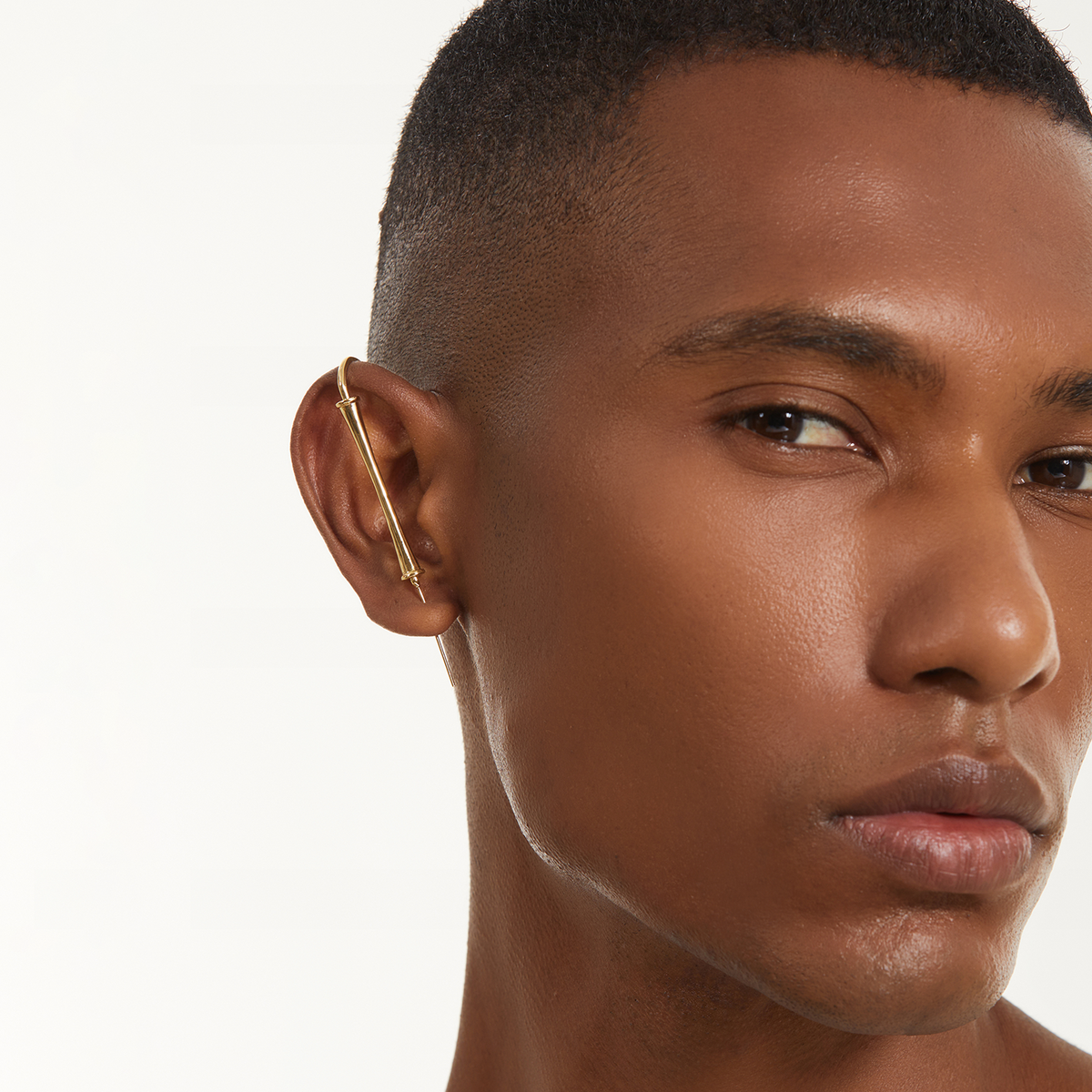 Pillar of Fortitude ear cuff in gold worn on the ear, profile view