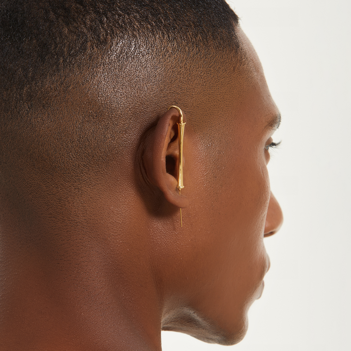 Pillar of Fortitude ear cuff in gold worn on the ear, profile view