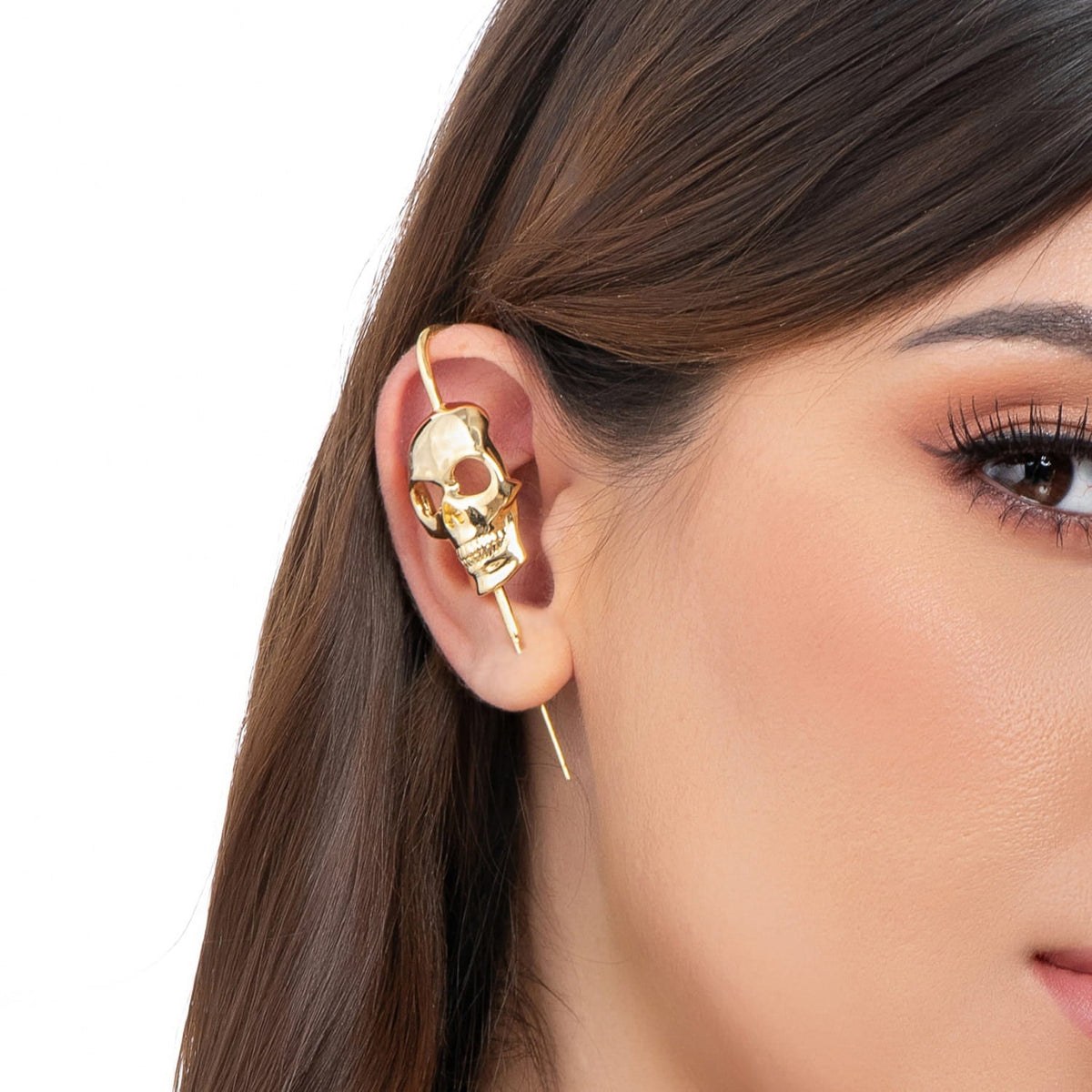 Memento Mori ear cuff in gold on a black ear form