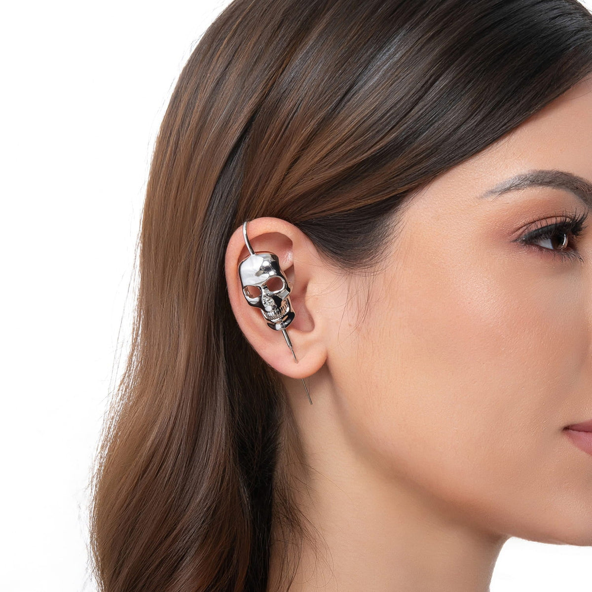 Memento Mori ear cuff in silver on a black ear form