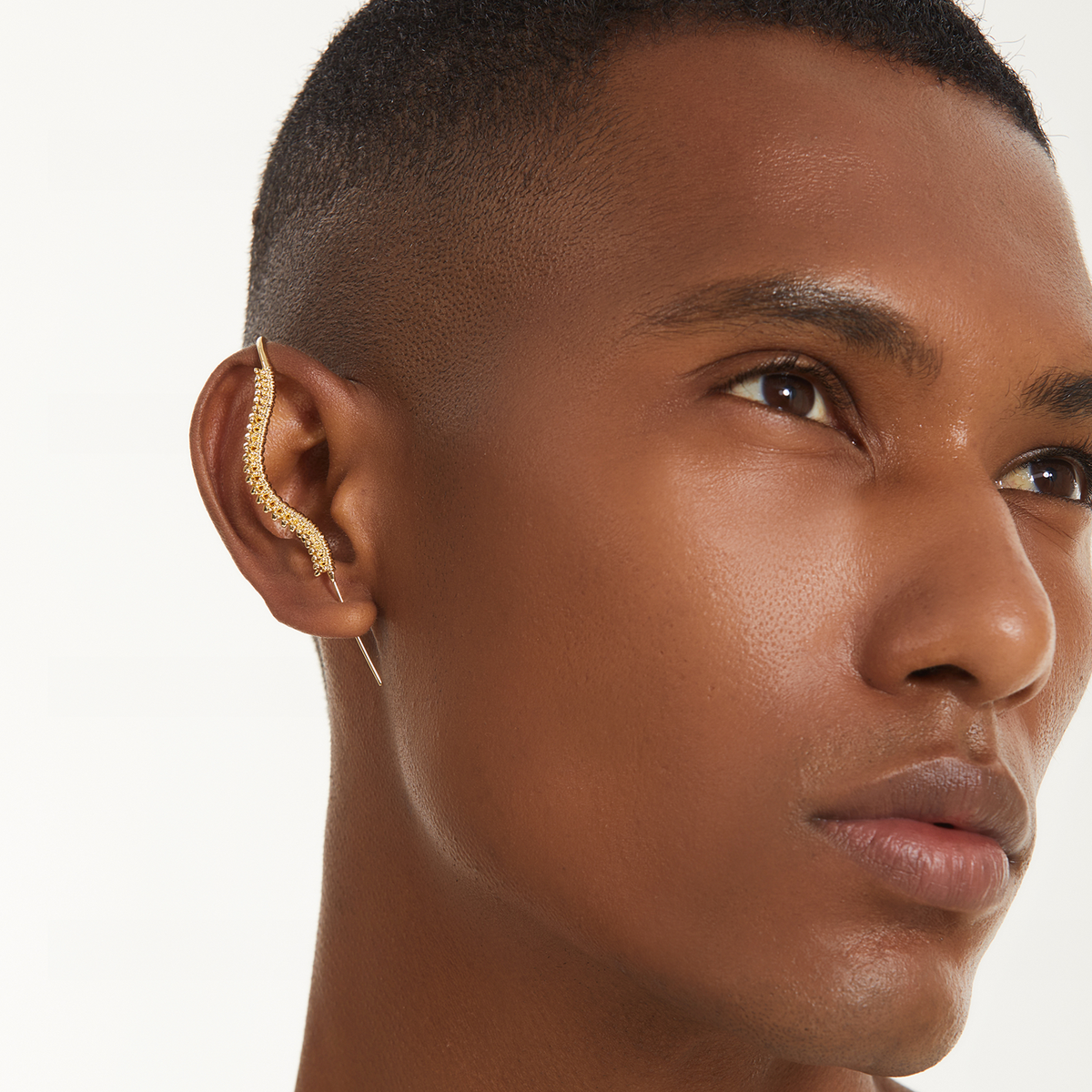 Spine-Chilling ear cuff in gold worn on the ear, profile view