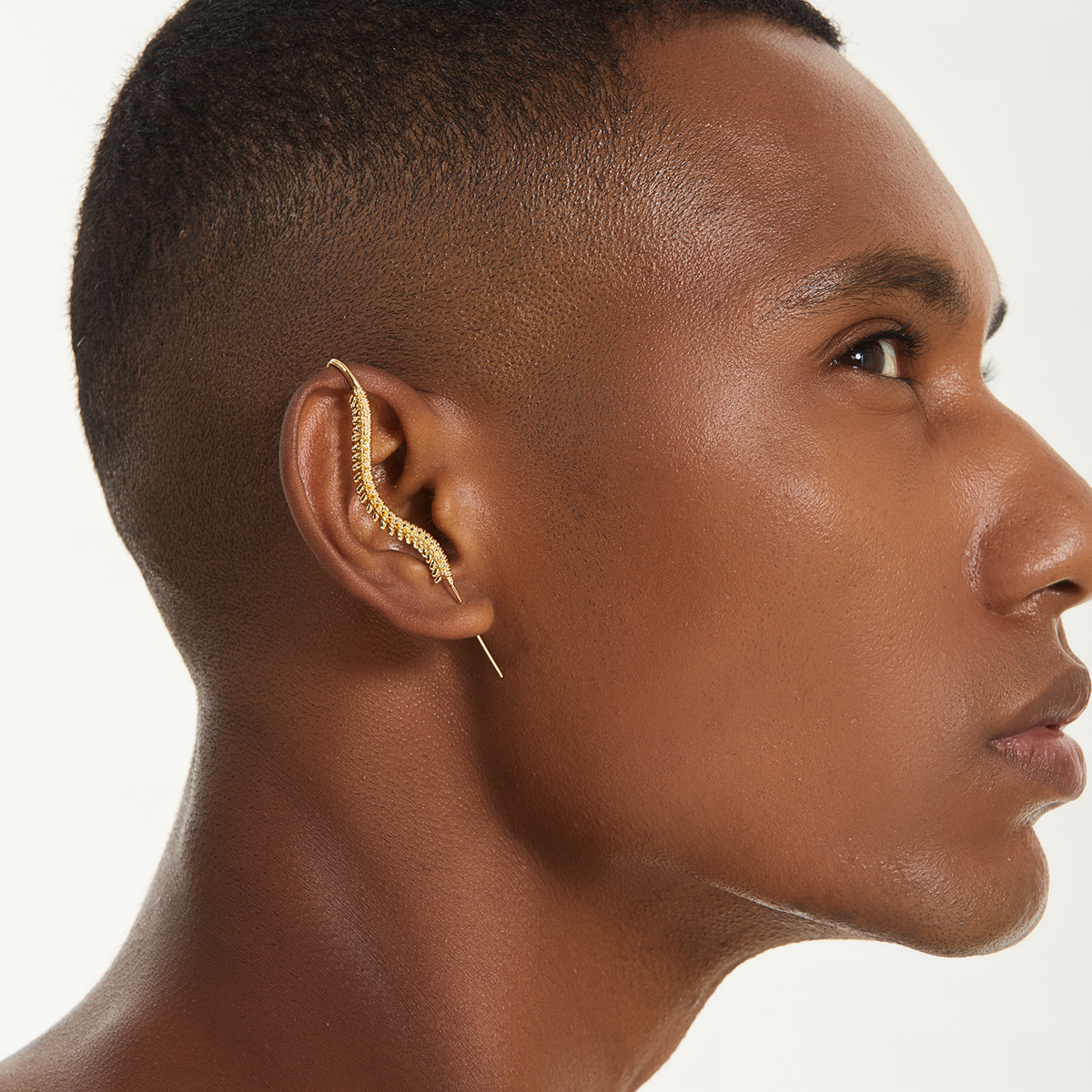Spine-Chilling ear cuff in gold worn on the ear, profile view
