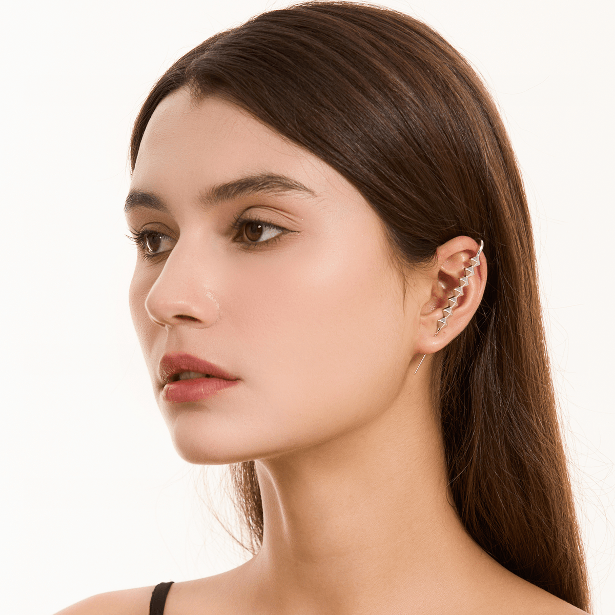 Studded ear cuff in silver worn on the ear, profile view